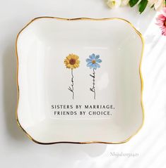 a plate with two flowers and the words sisters by marriage friends by choice