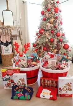 a christmas tree is decorated with red and white baskets filled with holiday gifts for children