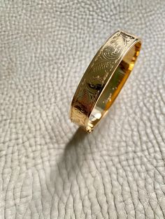 Made in 1962 - Wide Hinged Bangle in 18k gold - Etched Curls Pattern - Stockholm, Sweden - Size 7 Stunning vintage hinged bangle crafted in 18k yellow gold. Bangle was made in 1962 by maker GFP active 1945-1968. Bracelet has full Swedish hallmarks for maker, year, location and gold purity. By hand, the goldsmith etched a wonderful swirling curl pattern on one side of the bangle and polished the other side - you can wear her either way - a two in one! She is oval shaped measuring 7 inches inside Luxury Gold Plated Cuff Bracelet With Polished Finish, Timeless Gold Cuff Bracelet For Wedding, Vintage Yellow Gold Bangle Stamped 14k, Gold-plated Polished Cuff Bracelet For Formal Occasions, Luxury Yellow Gold Cuff Bracelet For Evening, Formal Gold-plated Polished Cuff Bracelet, Luxury Yellow Gold Evening Cuff Bracelet, Formal Gold Plated Cuff Bracelet With Polished Finish, Timeless Hallmarked Bangle As A Gift