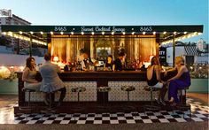 three people sitting at a bar on top of a roof