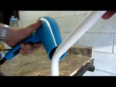 a person is using a blue and white hose to fix a sink faucet