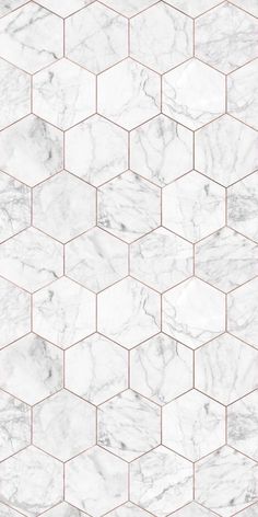 a white marble tile wallpaper with hexagonal tiles in the middle and gold lines