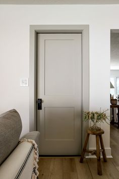 a living room with a couch and a door leading to the dining area is shown