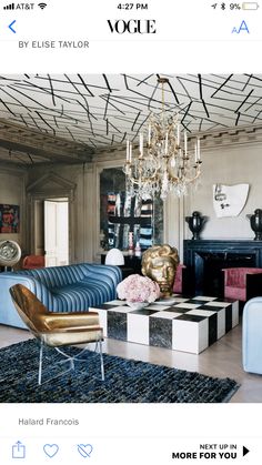 a living room filled with furniture and a chandelier hanging over the top of it