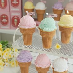 there are five ice cream cones in the display case, each with different colors and flavors