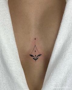 a woman's chest with a small tattoo on it