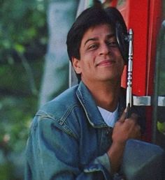 a young man holding onto a red door