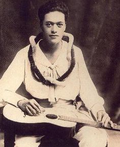 an old black and white photo of a man holding a guitar