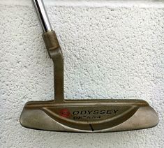 a close up of a putter on a white wall with the words odyssey written on it