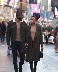 a man and woman are walking down the street