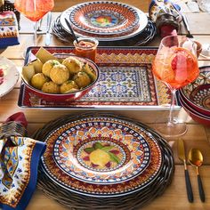 a table set with plates, bowls and utensils