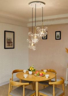 a dining room table with four chairs and a chandelier hanging from the ceiling