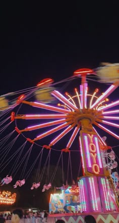 an amusement park at night with lights and rides