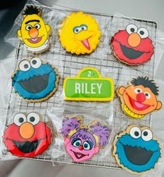 sesame street cookies are on a cooling rack with the names riley and elmo's