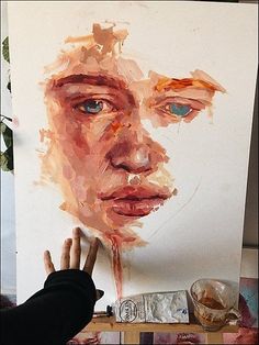 a person is painting a portrait on a canvas