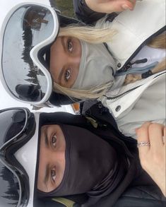 two women wearing ski goggles standing next to each other