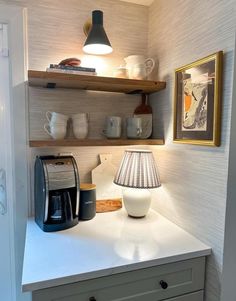 a kitchen counter with a lamp and coffee maker on it's shelf above the sink