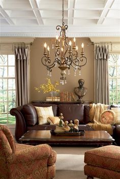 a living room filled with furniture and a chandelier hanging over the top of it