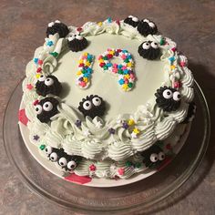 a birthday cake decorated with white frosting and colorful sprinkles is on a glass platter