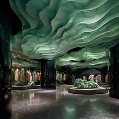 the interior of a clothing store with green and white waves on the ceiling, along with mannequins