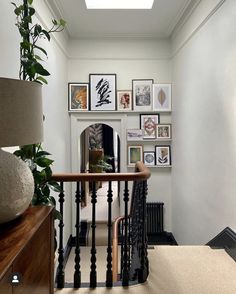 an entry way with pictures on the wall and stairs leading up to it's second floor