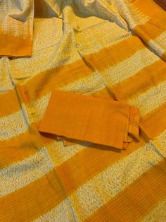 "A pure cotton saree using the \"Shibori\" (tie & dye) technique in a bright mustard yellow and white combination. Saree is completely handmade starting from weaving to dyeing. Condition: New Fabric: Pure 100% cotton Length: 5.5 metres Fall & Pico : Saree comes with fall and pico Blouse: Comes with running blouse piece. Customized stitching: available upon request with additional charges. Occasion: Casual, Wedding, Festivities, Party, Religious Note: We try to stay as accurate to the ori Yellow Cotton Silk Dupatta For Puja, Cotton Saree With Ikat Print For Festivals, Festive Yellow Cotton Dupatta, Yellow Cotton Dupatta With Traditional Patterns, White Cotton Dupatta With Bandhani Print, Cotton Dupatta With Ikat Print For Festivals, Yellow Cotton Dupatta For Festivals, Festive Cotton Saree With Ikat Print, Orange Cotton Dupatta With Pallu