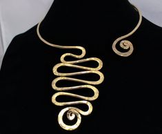 "This Open Collar Asymmetrical Necklace necklace is a Hand Hammered work of art. It will be the easiest necklace that you've ever put on in your life. Just slightly pull apart a few inches, slide it around your neck with a single hand and gently push it back to a comfy position. There are no clasps, no hooks, no connections. Be the envy, the talk of the town and stand out with this unique one of a kind body art. This is guaranteed comfort and be sure to get ready for lots of compliments. This is Elegant Spiral Necklaces For Jewelry Making, Modern Jewelry With Unique Spiral Design, Elegant Spiral Jewelry With Unique Design, Elegant Adjustable Swirl Necklace, Modern Handmade Spiral Jewelry, Handmade Swirl Jewelry With A Modern Twist, Modern Twist Hand Forged Spiral Jewelry, Gold Spiral Necklaces For Jewelry Making, Adjustable Artsy Gold Necklace