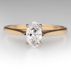 an oval cut diamond ring in yellow gold