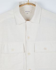 The Harshil is a relaxed fitting camp collar shirt with two oversized patch front pockets and corozo buttons. A combination of pomegranate peel and iron filings have been used to naturally dye the yarns that make up this border stripe design. Handwoven on a traditional frame loom. Kora is one of our signature handwoven fabrics, a breathable woven cotton that protects against the harsh heat. It has a soft hand, a relaxed look and feel and is ideal for the summer weather. - 100% Handwoven cotton- Iron Filings, Pomegranate Peel, Camp Collar Shirt, Natural Detergent, Traditional Frames, Handwoven Fabric, Summer Weather, Pocket Shirt, Naturally Dyed