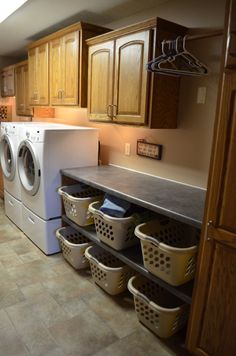 a washer and dryer in a laundry room with wooden cabinets on the wall