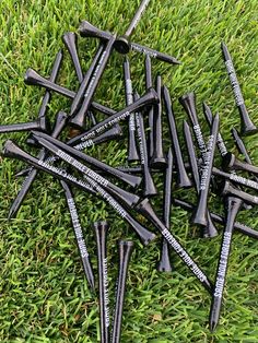 a pile of black screws laying on top of green grass