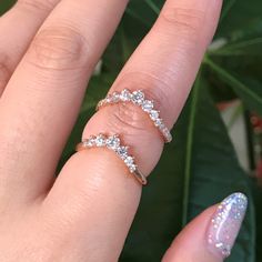 a woman's hand with three diamond rings on top of her finger, and one ring in the middle