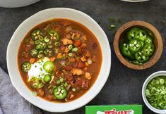 the soup is prepared and ready to be eaten with green peppers, onions, and sour cream