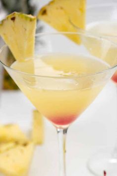 two martinis with pineapple garnish in them