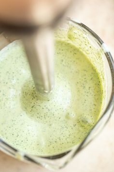 a blender filled with green liquid on top of a table