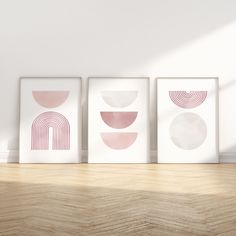 three framed art prints on a wall in a room with wood flooring and white walls