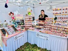 a woman standing in front of a table filled with lots of different types of items