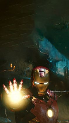 the iron man is holding out his glowing hands