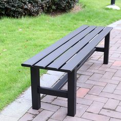 a black bench sitting on top of a brick walkway