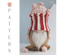 a knitted gnome with a red and white striped hat