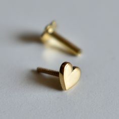 "Sweet little solid gold Heart stud, handcrafted in 14k gold, this pin is available in a variety of closure options for different types of piercings. A cute stud for all ages! * Gold - 14K Solid Gold * 4mm*4mm * Standard length of the post below design is 6-7mm. It can be adjusted as per requirements as well. DIAMOND NOSE PIN : https://www.etsy.com/listing/267480507/ ROUGH EMERALD NOSE STUD : https://www.etsy.com/listing/267480037/ If you like this pin, please press \"Pin it\" button on the righ Flat Ear Piercing, Different Types Of Piercings, Tiny Nose, Gold Heart Stud Earrings, Gold Heart Studs, Types Of Piercings, Nose Pin, Nose Ring Stud, Ear Piercing