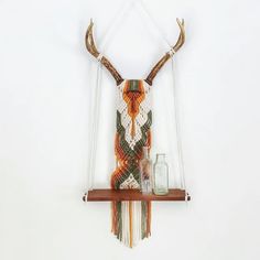 a deer head hanging on the wall next to a shelf with some jars and glasses