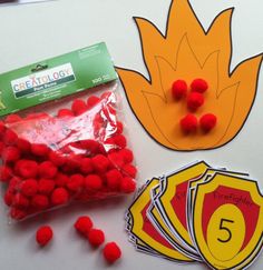 some red candies are sitting on a table next to a bag of fireballs