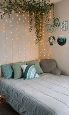 a bed sitting under a tree with lots of lights hanging from it's headboard