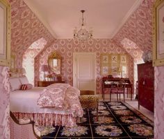 a bedroom with pink and gold wallpaper, chandelier and bed in it