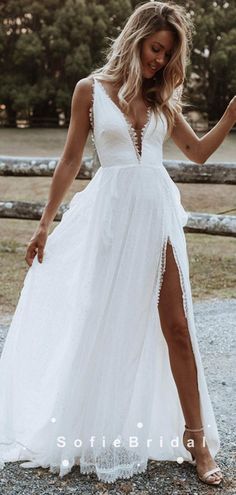 a woman in a white dress standing on gravel