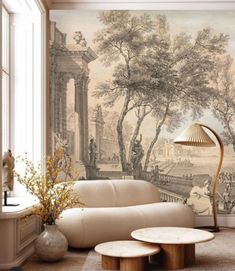 a living room with a large mural on the wall and two tables in front of it