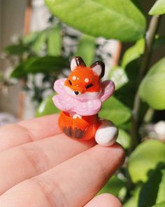 a small toy fox sitting on top of a hand