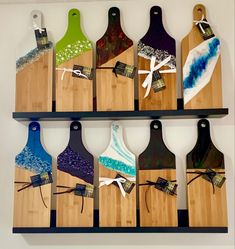 several wooden cutting boards with different designs on them hanging from a wall in a room