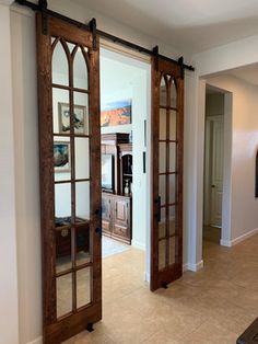 an open door leading to a living room and dining room with large windows on the wall